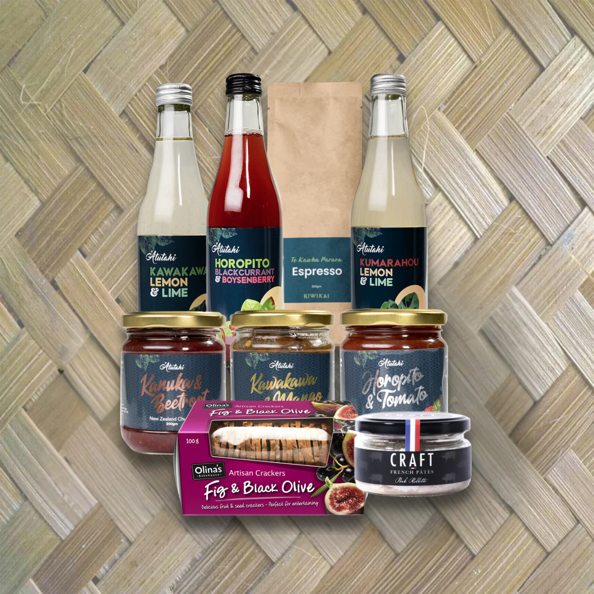 Atutahi Gift Rua set featuring Kawakawa Lemon & Lime, Horopito Blackcurrant, Kiwikai Espresso, artisan chutneys, and Olina’s crackers on a woven flax background.